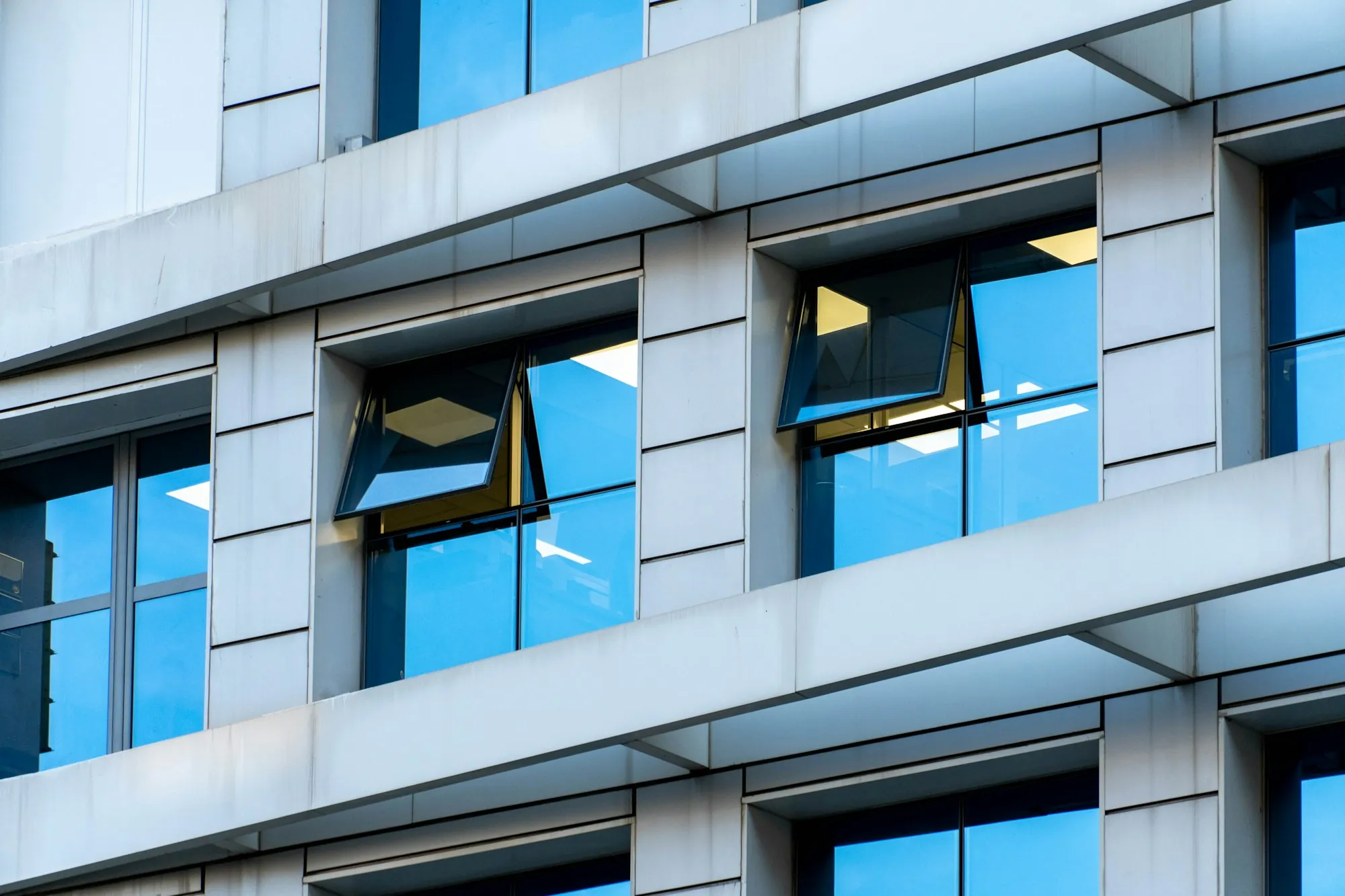 Office building facade with white frames and blue windows