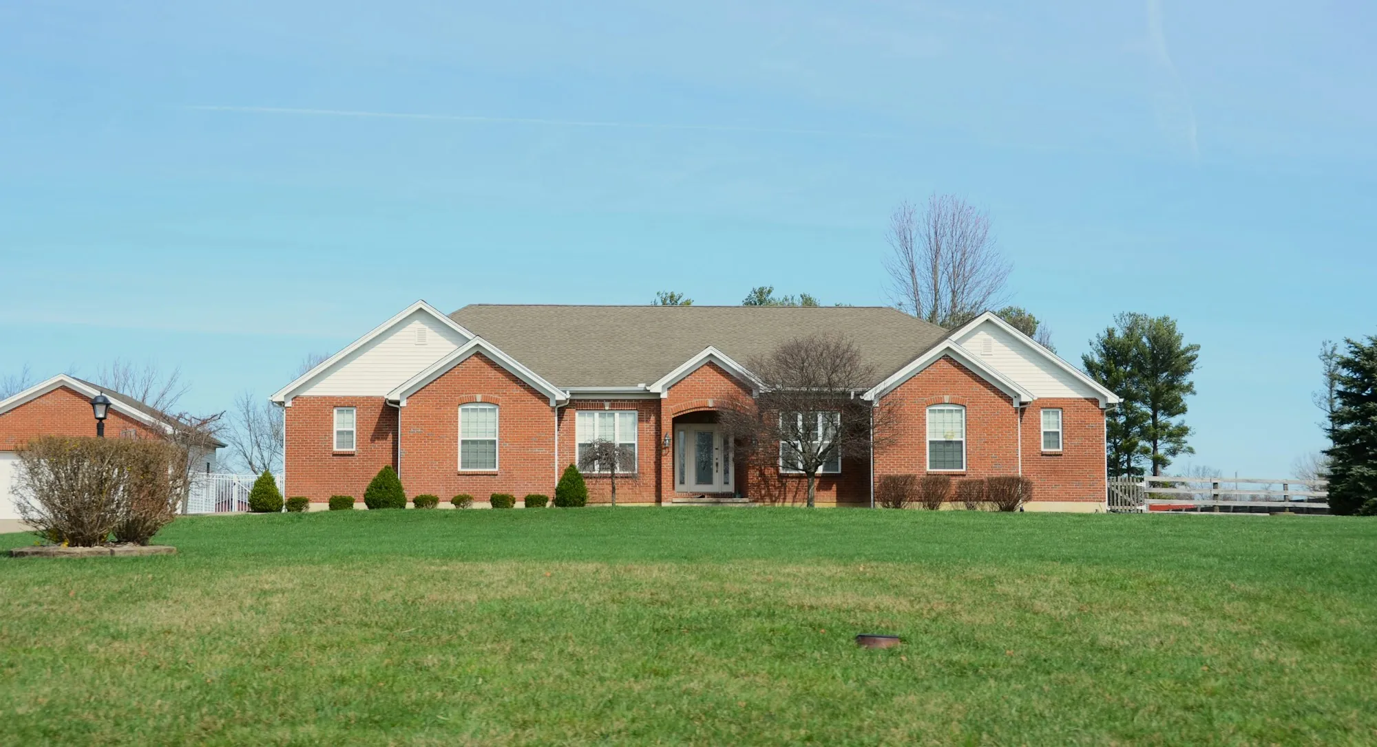 Single-story brick ranch house on a wide lawn